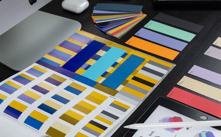 Colour swatch cards and printed palettes arranged on a desk with a stylus